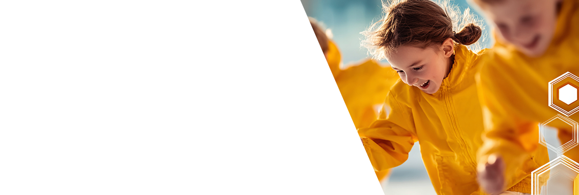 Two people in yellow raincoats running outdoors with a blurred background