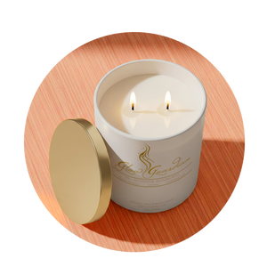 White candle in a glass container with a gold lid on a wooden surface